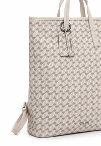 Sac fourre-tout avec motif géométrique en beige et marron clair, présentant une texture lisse, deux poignées et une étiquette en cuir avec quincaillerie argentée.