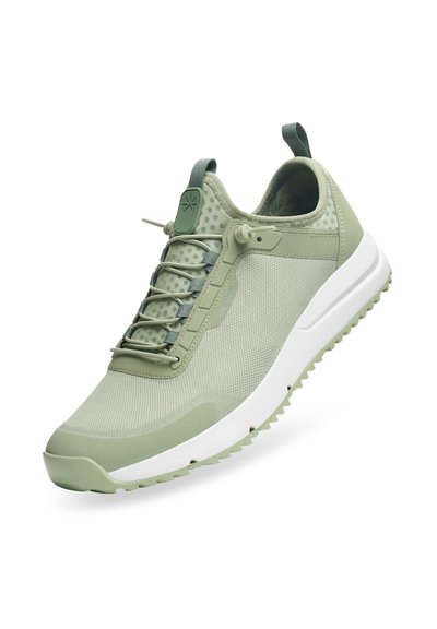 Ljust gröna sportskor med meshtopp, elastiska snören och en vit sula med texturerad detaljer och gummibana.