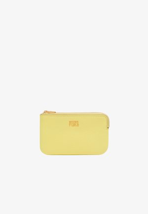 Kollane nahast kott, millel on tekstuuriga viimistlus, kuldne tõmblukk ja muljega logo. Kompaktne ristkülikukujuline kuju, minimalistlik disain.