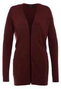 Burgundy kofta i texturerat tyg med V-ringning, öppen framsida och två framfickor. Ärmarna är långa och åtsittande.