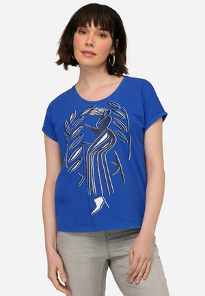 Camiseta de algodón azul con escote redondo, mangas cortas y un diseño gráfico que presenta una figura con rayas y tacones altos.