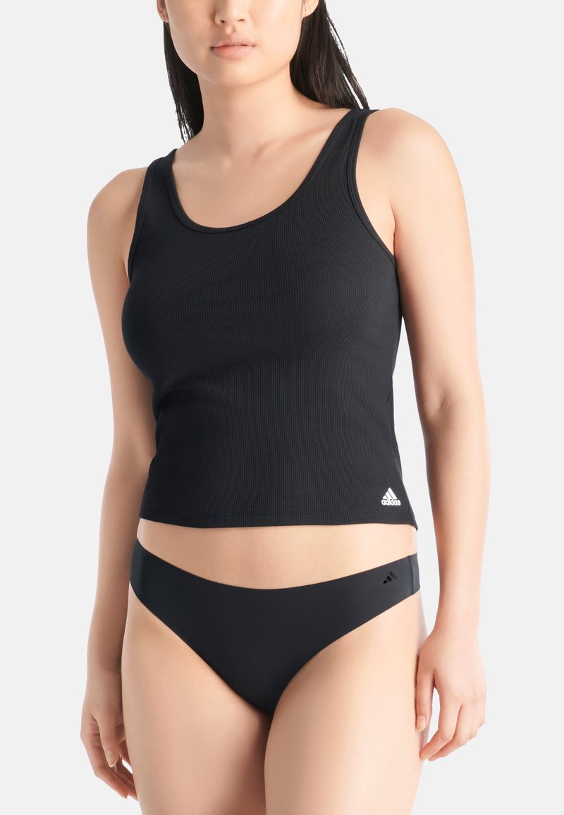 Svart rippad linne med rundad halsringning och diskret Adidas-logotyp. I kombination med matchande svarta bikinitrosor med minimal täckning.