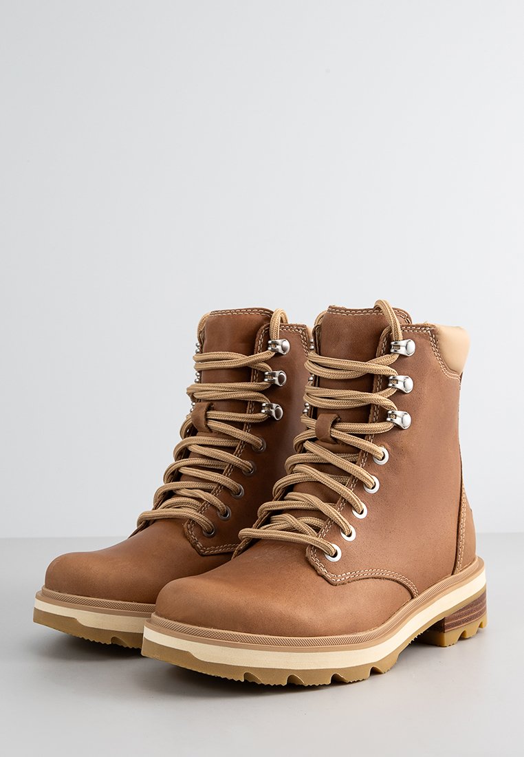 Braune Lederschuhe zum Wandern mit beige Schnürsenkeln, metallischen Ösen und einer beige Gummisohle. Die Stiefel haben eine glatte Textur und gepolsterte Knöchelunterstützung.