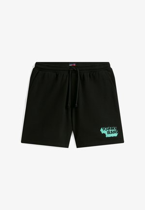 Schwarze Sweatshorts aus weichem Stoff mit elastischem Bund und Kordelzug. Auf dem linken Bein befindet sich ein türkisfarbenes "TOMMY JEANS"-Logo.
