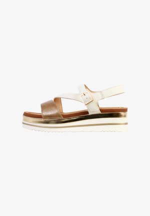 Witte en bronzen open-teen sleehak sandaal met enkelriem, gouden gesp en een witte zool met een metallic gouden streep.