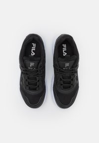 Baskets noires de sport avec tige en maille, design structuré, bout rond et semelle en caoutchouc blanc. Comprend des lacets et le logo Fila sur la languette.