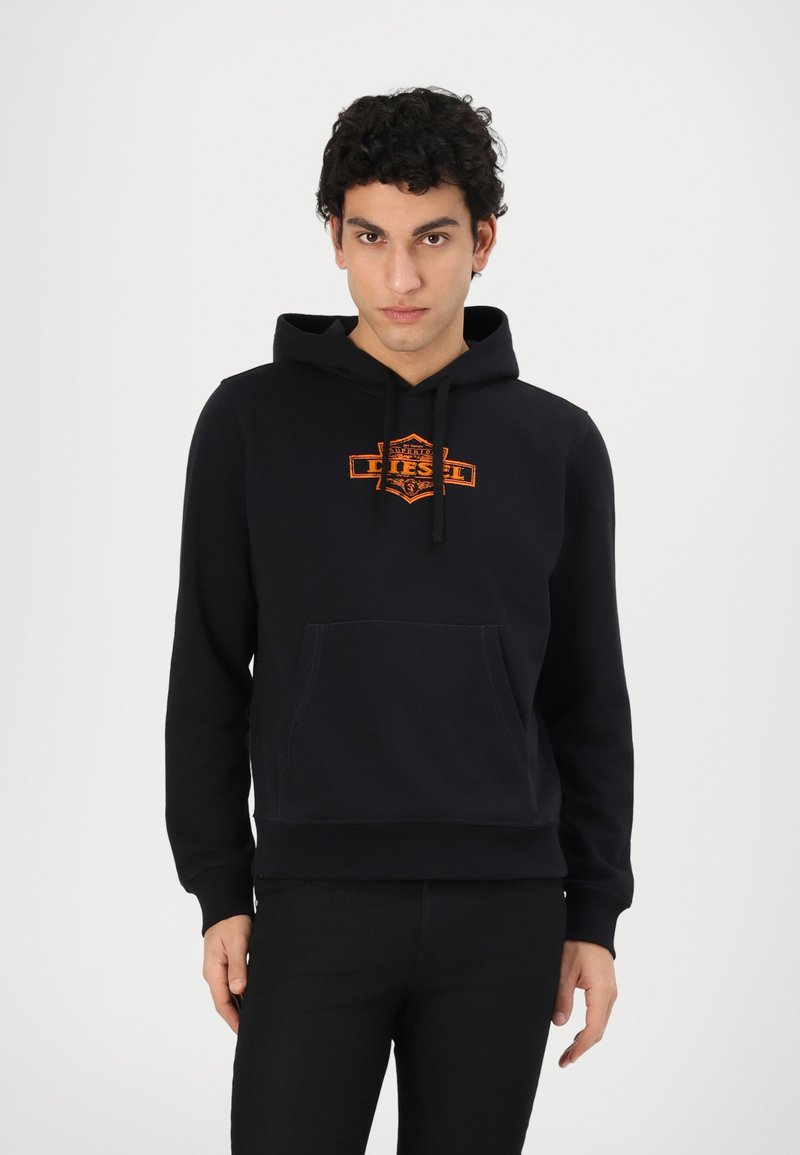 Svart hettegenser med oransje brodert logo på brystet, med frontlomme, snor i hetten og ribbestrikkede mansjetter. Glatt tekstur.