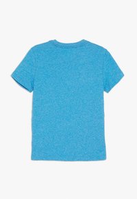 Koszulka z krótkim rękawem w kolorze heather blue, wykonana z miękkiej bawełny. Posiada okrągły dekolt oraz prosty, jednolity design bez grafik.