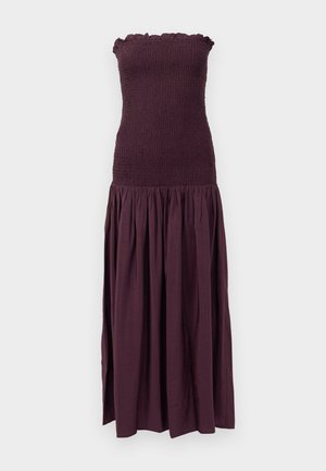 Vestido sin tirantes de color púrpura oscuro con corsé fruncido, escote con volantes y falda fluida y fruncida. Está hecho de una tela ligera y texturizada.