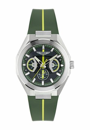Reloj de pulsera verde con correa de rayas amarillas, caja plateada, tres subesferas que muestran el día, la fecha y la hora en formato 24 horas, y el logo de Aston Martin en la esfera.