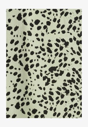 Tela verde claro con una textura que presenta un patrón moteado negro, que recuerda a manchas de animales, dispersas por toda la superficie.