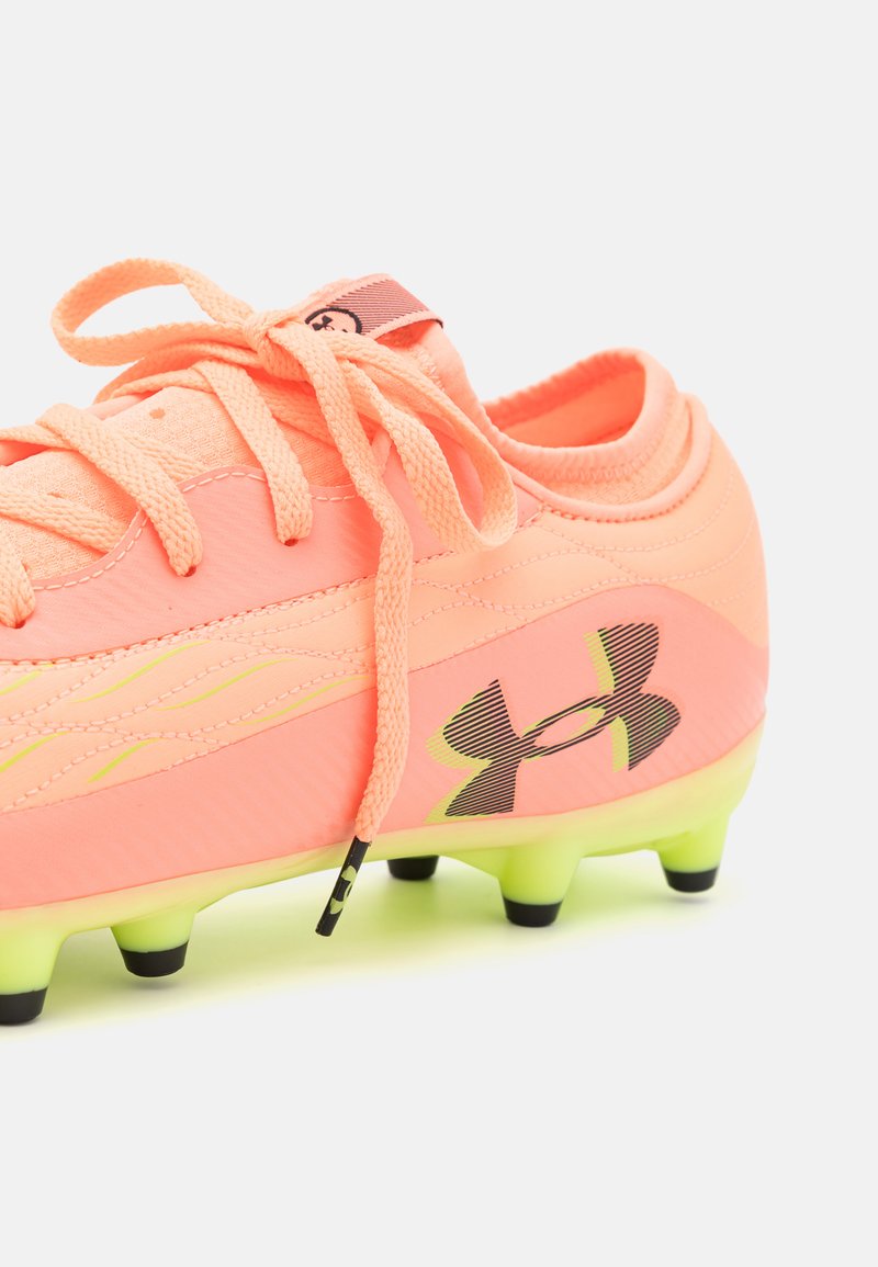 Botín de fútbol de un brillante color rosa neón con una parte superior texturizada, acentos negros, tacos negros y cordones, que presenta un logo distintivo en el lateral.