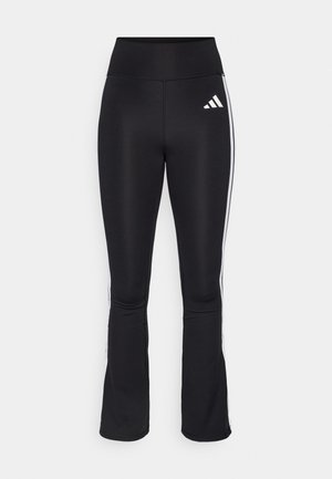 Schwarze Sporthose mit hohem Bund, ausgestelltem Beinschnitt und weißen Seitenstreifen. Mit dem Adidas-Logo auf dem linken Oberschenkel.