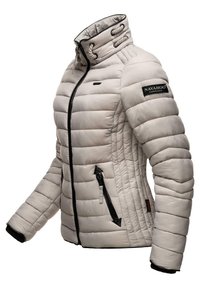 Light grey puffer jacket with quilted texture, high collar, zip pockets, and a black logo patch on the upper arm. Features black zipper accents.