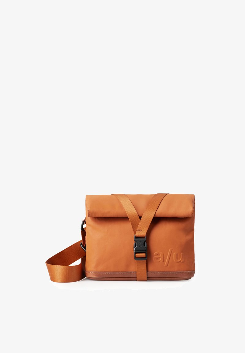Orange wasserdichte Messenger-Tasche mit Klappverschluss, verstellbarem Schultergurt und schwarzem Zubehör. Mit geprägt Logo auf der Vorderseite.