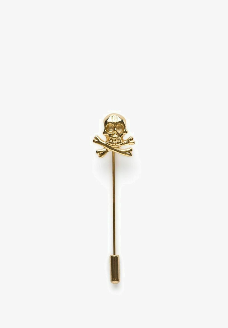 Guldfärgad metallstiftpin med ett skalle och korsade ben-design, med texturerade detaljer på skallen och en slät yta på pinnen.