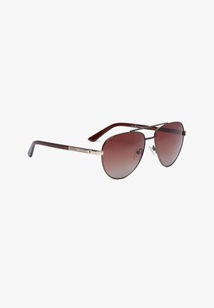Brązowe gradientowe okulary przeciwsłoneczne aviator z cienką metalową oprawką i ciemnobrązowymi zakrzywionymi zausznikami na białym tle.