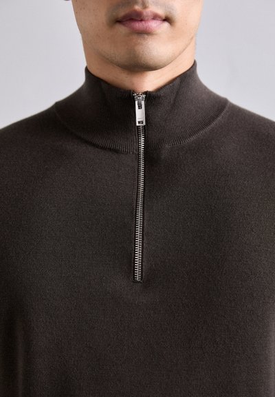 Maglione marrone con zip, caratterizzato da un colletto alto, texture liscia e zip metallica. Design aderente senza motivi o accenti visibili.