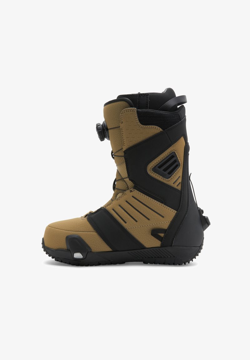 Snowboard boot in tan and black. Features textured material, a tall design, adjustable lacing system, and rubberized sole with grip.