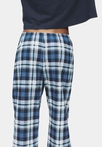 Pantalones de cuadros de algodón en colores azul, negro y blanco, con un corte holgado y una cintura elástica para mayor comodidad.