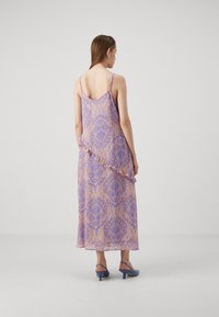 Satiini maxi-mekko purppurassa ja persikankeltaisessa värissä kukkakuviolla, jossa on säädettävät olkaimet ja röyhelöhelma. Yhdistetty sinisiin korkokenkiin.