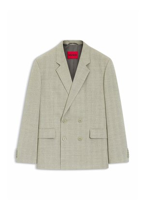 Lichtbeige dubbelgeknoopt jasje met inkeping-revers, vier knopen aan de voorkant, twee klepzakken en een zichtbaar rood "HUGO" label aan de binnenkant van de kraag.