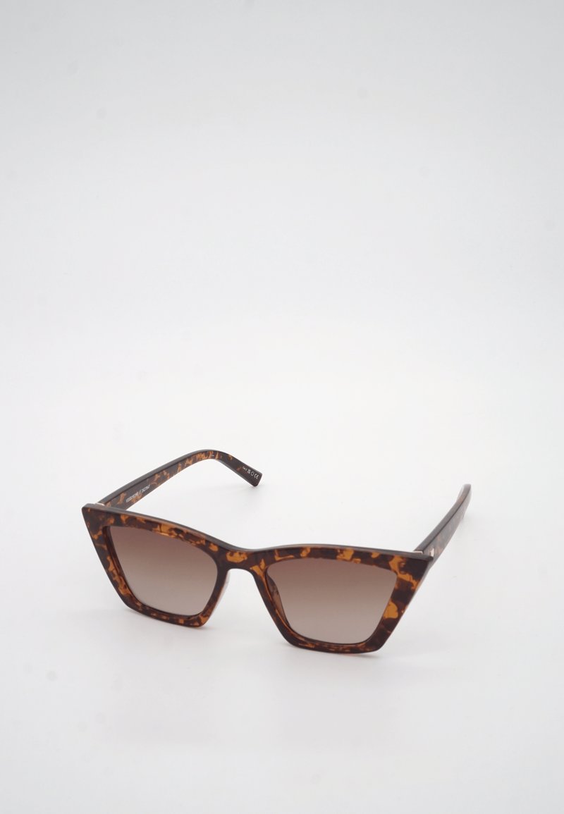 Γυαλιά ηλίου με σκελετό σε σχήμα γάτας και καφέ φακούς με βαθμιαία απόχρωση, σε λευκό φόντο.