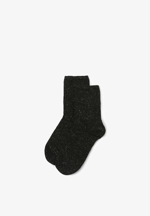 Schwarze Socken mit einem strukturierten Rippdesign, aus einem weichen, stretchfähigen Material gefertigt. Sie besitzen eine leicht gewebte Optik mit subtilen Streifen.