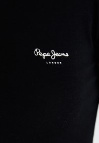 Material textil negru cu logo-ul brodat alb "Pepe Jeans London" centrat în zona pieptului.