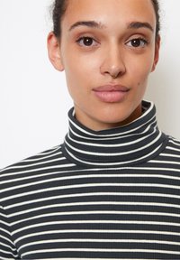 Stribet turtleneck i mørkeblå og hvid, lavet af ribbet stof. Har en høj krave og en tætsiddende pasform, som fremhæver en slank silhuet.