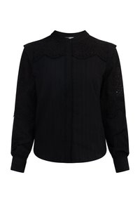 Zwarte blouse met lange mouwen, met textuurstof, decoratieve oogjes op de schouders en een knoopsluiting aan de voorkant.