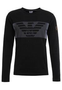 Svart långärmad t-shirt med ett grått grafiskt emblem på bröstet, med horisontella ränder och en texturerad detalj. Logotyp på ärmen.