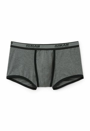 Grijze herenslipboxers gemaakt van zachte stof, met een zwarte tailleband waarop het logo "Intimissimi Uomo" staat en contrasterende zwarte afwerking.