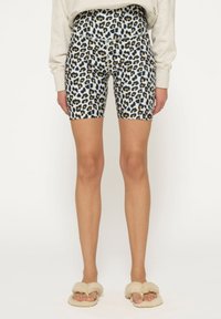 Løveprint cykelshorts med høj talje. Fremstillet af strækbart materiale, der har sorte, brune og gule pletter på en lys baggrund.