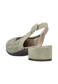 Groene slingback-schoen met een gestructureerde geweven bovenkant en soepele leren accenten. Chunky hak en verstelbare gesp sluiting aan de achterkant.