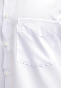 Chemise blanche habillée en gros plan montrant un devant boutonné et une seule poche poitrine avec un détail de couture subtil.