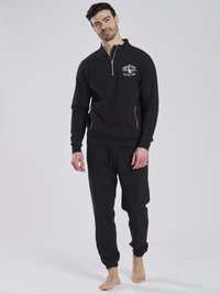 Schwarzer Pullover mit einem Viertel-Reißverschluss und gesticktem Bergdesign, kombiniert mit passenden schwarzen Jogginghosen mit elastischen Bündchen.