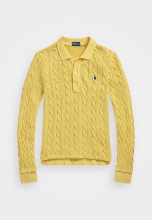 Gul strikket polo-shirt med lange ærmer, kabelmønster, krave og tre knapper. Har lille blåt logo på venstre bryst.