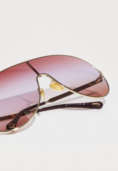 Pilotbriller med gradient rosa linser, ramme i gulltone metall og mørk burgunderarmer, med elegante aksentdetaljer.