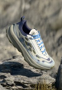 Hellblauer und weißer Laufschuh mit einem Mesh-Obermaterial, gemustertem Design, auffälligen Schnürsenkeln und dicker Gummisohle.