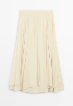 Gonna beige, lunga fino al ginocchio, realizzata in un morbido tessuto, con pieghe e un design fluido con orlo curvo. Stile minimalista, senza hardware visibile.