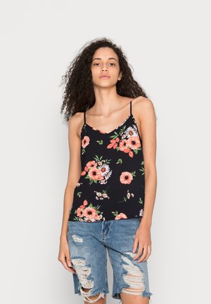 Camisola preta com padrão floral apresentando flores rosas e brancas, alças finas delicadas e um corte descontraído, combinada com calções de ganga rasgados.