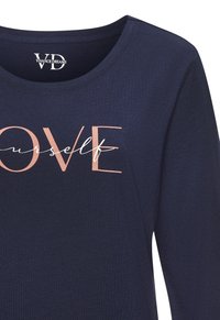 Navy blue long-sleeve shirt with a round neckline and white and rose gold "LOVE yourself" text graphic on the front. Soft fabric texture.