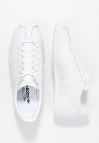 Vita sneakers i läder med slät yta, rund tå, sex hål för skosnören, tre sidostripes och texturerad gummisula.