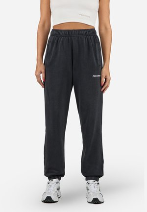 Dark gray sweatpants in a tapered design with an elastic waistband, side pockets, and a white logo on the left thigh.