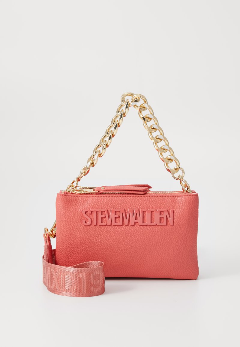 Coral pink faux leather handbag with a gold chain strap, featuring embossed "STEVE MADDEN" logo and a detachable strap. Textured surface.