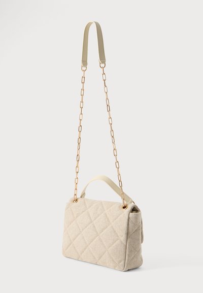 Sac bandoulière matelassé beige avec une courte poignée supérieure, une longue bandoulière chaîne dorée et une poche latérale.