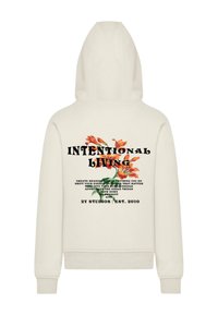 Felpa crema con cappuccio regolabile. Design floreale sul retro con il testo "VIVERE INTENZIONALMENTE" in nero. Tessuto morbido.