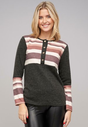 T-shirt à manches longues de couleur gris foncé avec un motif rayé en rose et blanc. Présente un col boutonné et une texture de tissu douce.