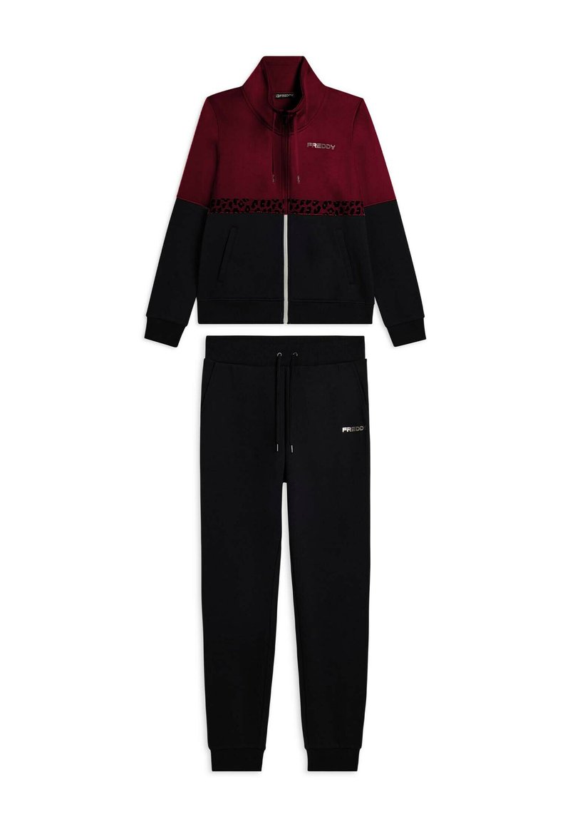 Giacca zip-up bordeaux e nera con striscia leopardata più pantaloni jogger neri con cordino, entrambi con il logo Freddy davanti.